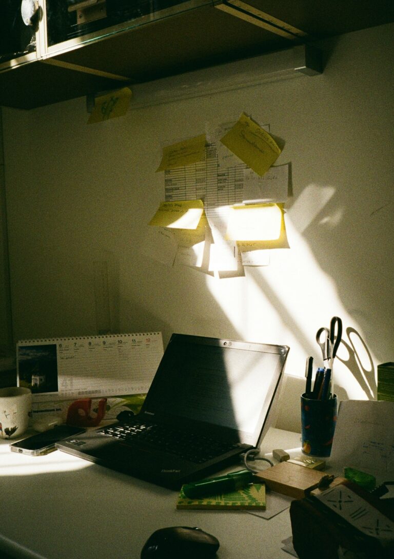 Notion AI review 2026: a clean solo-founder workspace with laptop and sticky notes